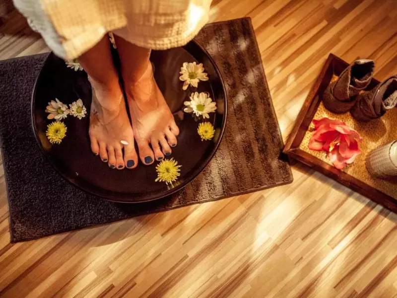 Masaż stóp Terapeutka wykonująca rytuał obmycia stóp w misie. Na wodzie unoszą się żółte kwiaty. Rytuał ten jest elementem Pakietu Tajski Sen