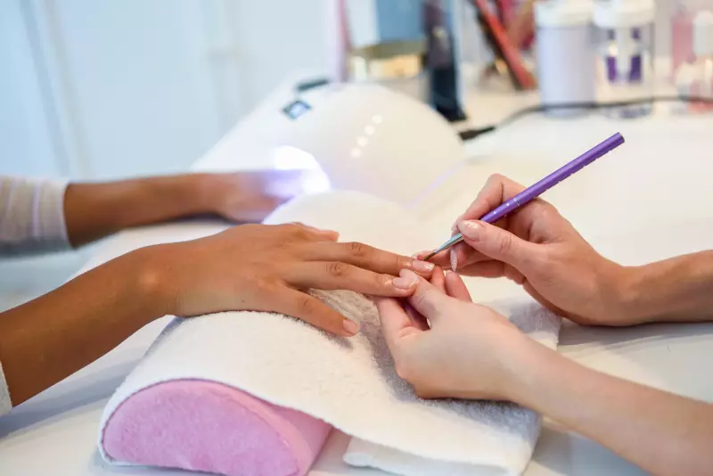 Manicure spa klasyczny, hybrydowy i japoński. Kosmetolog trzyma dłoń klientki, poprawia kształt paznokci.